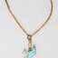 Detail of the front of the gold toned metal necklace with a small blue bird pendant and a small faux pearl. 