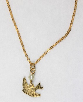 Detail of the back of the gold toned metal necklace with a small bird pendant and a small faux pearl. 