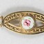 Front of a gold toned metal hair clip with a circular enamel inlay.