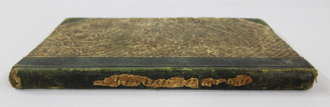 Spine of the Wodonga Police register or diary used for recording day-to-day duties in 1855-1857, with a fragmentary inscription. 