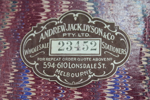 Adhesive paper label on the marbled paper surface of the inside front cover.