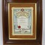 Dark brown wooden frame on a colour certificate for past officers in the Wodonga sub-branch of the Victorian Branch of the Australian Railways Union, with a black and white 10 cm scale.