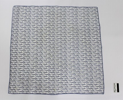 Scarf with the Sarah Coventry logo printed repeatedly in blue on a white background, with a black and white 5 cm scale.