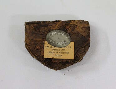Lump of tobacco with Havelock Tobacco makers mark on tin insert, with manufacture details on paper