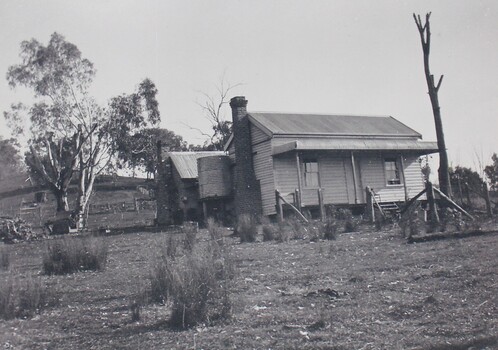 Black and white photograph of a farm house surrounded by trees 