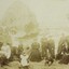 A sepia group portrait of adults and children on a beach, wearing Victorian era clothing. 