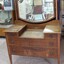 Wooden dresser with a mirror, two small drawere and two large drawers with circular recessed metal handles.