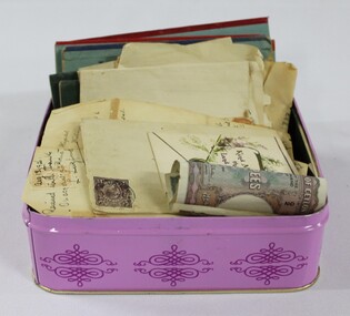 A purple tin full of letters, foreign money and savings bank passbooks