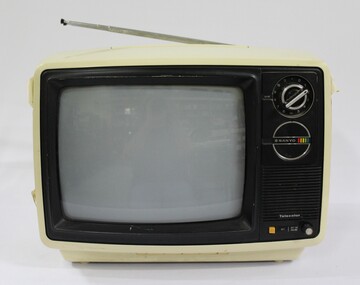 Cream and black plastic Sanyo colour televison, with the Sanyo logo and one large circular VHF control knob for the different channels on one side and one small off-on volume knob at the bottom on the same side.