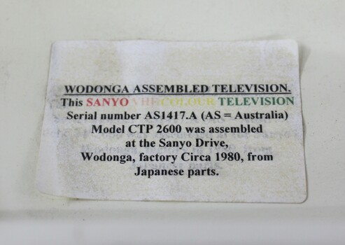 Paper label attached to the upper back of television.