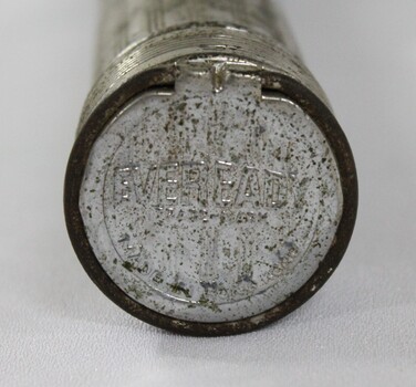 End of a five cell metal torch with "EVEREADY" and "MADE IN HONG KONG" embossed in the surface.