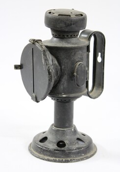 Side view of a black painted metal signal lamp.