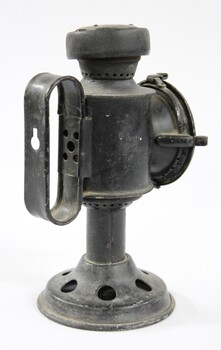 Back view of a black painted metal signal lamp with a elongated oval handle.