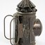 Black painted metal signal lamp with two thin elongated oval shaped handles at the back.
