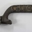 Dark brown cast iron can opener with the word 'GUARD' in raised letters on the side of the handle.