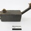 Side of a rectangular grey metal lamp with scale.