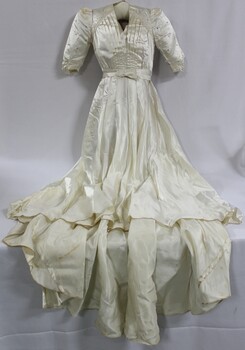 A floor length white satin wedding dress with structured sleeves and studded diamantes 