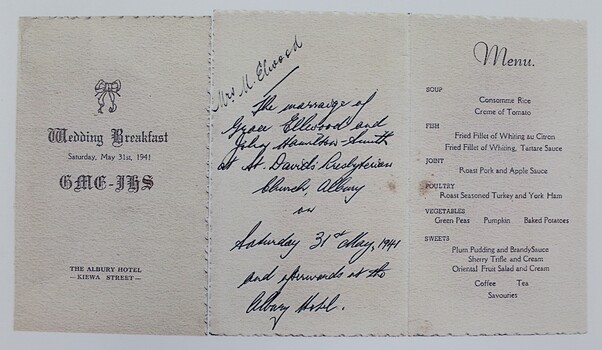 A cream coloured invitation featuring a menu and a handwritten inscription.