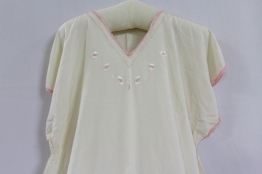 Close up of pink hand stitched embroidery on collar and sleeves