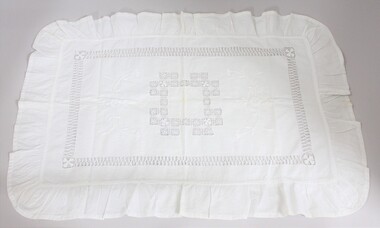 A handmade white pillow sham with needlework