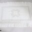 A handmade white pillow sham with needlework