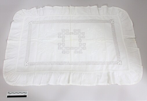 A handmade white pillow sham with needlework