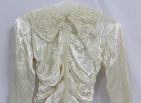 A silk wedding dress with fitted bodice and lace collar
