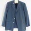 Front of a blue Victorian Railways jacket, with the VR logo stitched on each lapel and silver buttons.