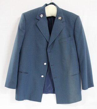 Front of a blue Victorian Railways jacket, with the VR logo stitched on each lapel and silver buttons.