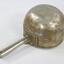 Underside of a large aluminium scoop with a handle soldered on one side edge.