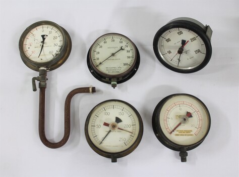 Five metal and glass water pump pressure gauges.