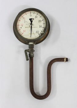 Metal and glass water pump pressure gauge with a U-shaped pipe and lever attached. Deteriorated inscription "-HOMPSONS (CASTLEMAINE)  LT-".