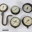 Five metal and glass water pump pressure gauges