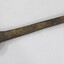 Large cast iron spanner with some red/brown rust corrosion and light brown surface dirt.
