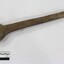Large cast iron spanner with some ed/brown rust corrosion and light brown surface dirt. Black and white 10 cm scale in the foreground.