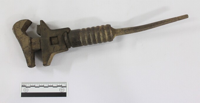 Large cast iron shifter wrench with scale in the foreground.