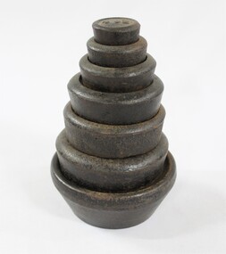 Set of seven metal weights with imperial measurements stacked from 4 oz. at the top to 7 lb. at  the bottom. 