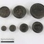 Set of seven metal weights with imperial measurements from 4 oz. to 7 lb., with a black and white 10 cm scale in the foreground.
