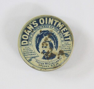 A round tin with branding and manufacturers information, and an illustration of man with a moustache. 