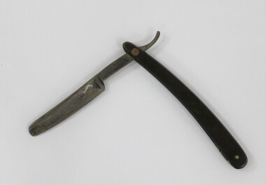An open cut throat razor with black plastic handle