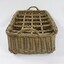Narrow end of a rectangular wicker crate for delivering bottled drinks with 12 compartments and handles at each end.