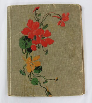 An olive green photographic album with a red, green and yellow floral motif on the front cover. 