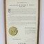 Thin wooden frame on a certificate with the text in black proclaiming the Shire of Wodonga as a City dated to 1973. Embossed gold seal on the left side of the text in the  lower part of the certificate.