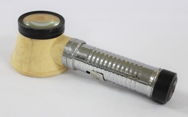 Side view of a metal and plastic flashlight magnifying glass.  