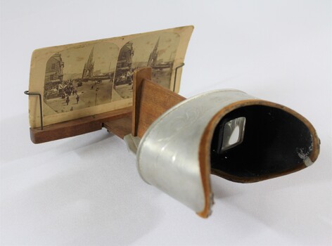 Side view of a stereoscope with a cardboard 'view' of a streetscape 