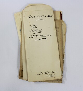 A stack of papers with handwriting in black ink 