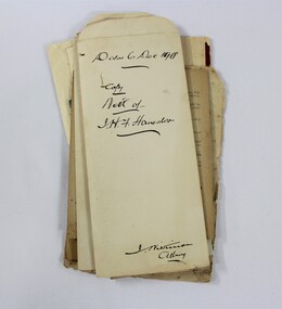 A stack of papers with handwriting in black ink 