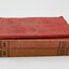 Three red cloth bound books stacked vertically. 