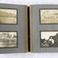 Open photograph album showing a picture of a bridge over a river, and of a woman holding flowers. 