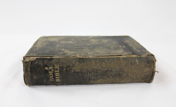 A black cloth bible with Holy Bible embossed on the spine in gold  